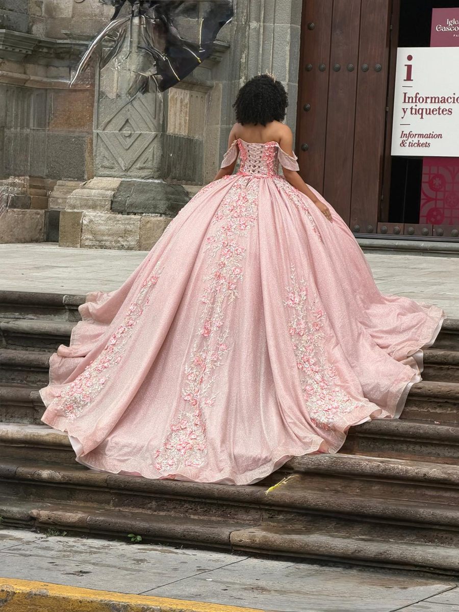 Quinceañera in a pink gown on the old cathedral steps