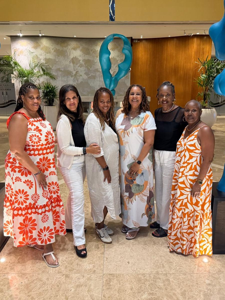 Group of members posing in The Ocean Club lobby between blue sculptures