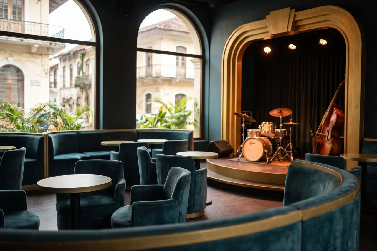 A velvet-lined jazz club interior with a stage set for a live band