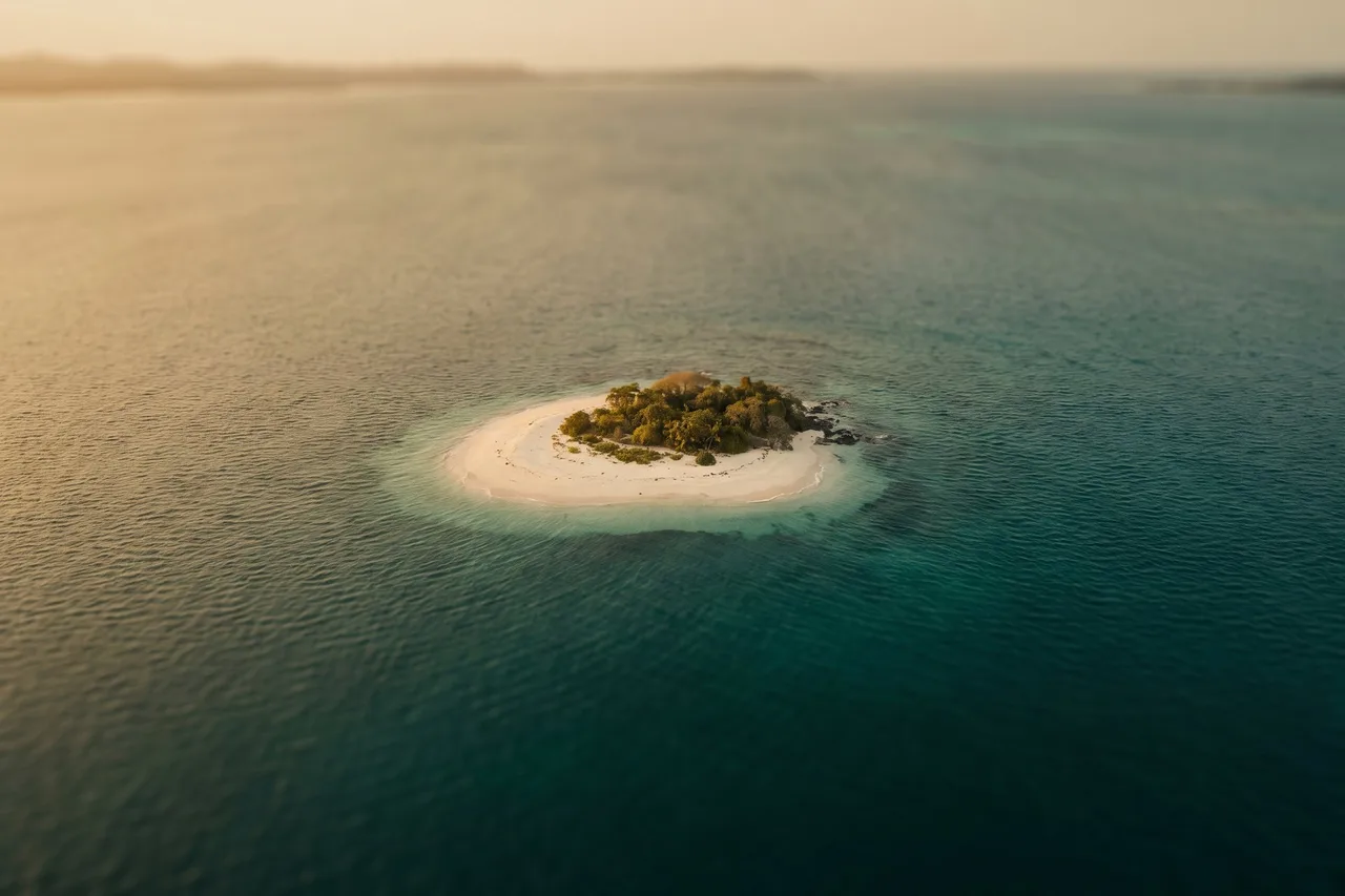A tiny white-sand island surrounded by turquoise water in the Pearl Islands